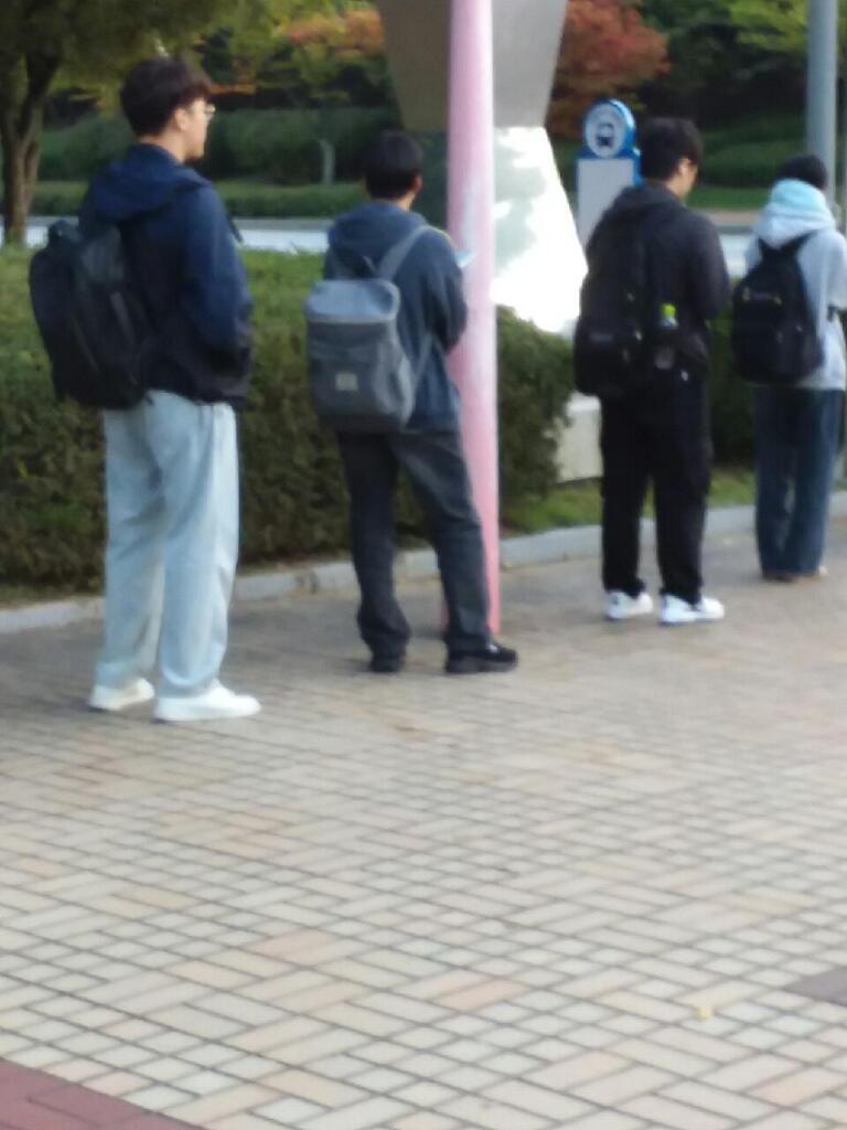 フードTシャツ ジーンズの眼鏡をかけた大学生