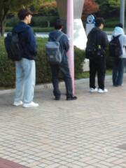 フードTシャツ、ジーンズの眼鏡をかけた大学生