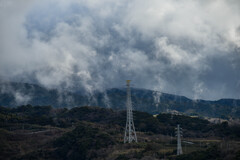 煙る山