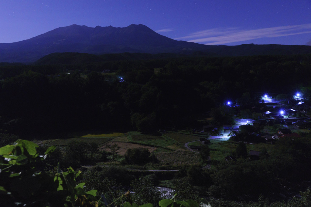 月明かりに照らされる御嶽山と農村