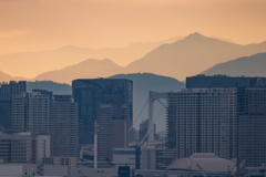 ビル群と平野を隔てる山々