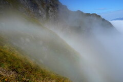 岩稜に掛かる白い虹