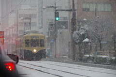 雪降る中チン電が走る