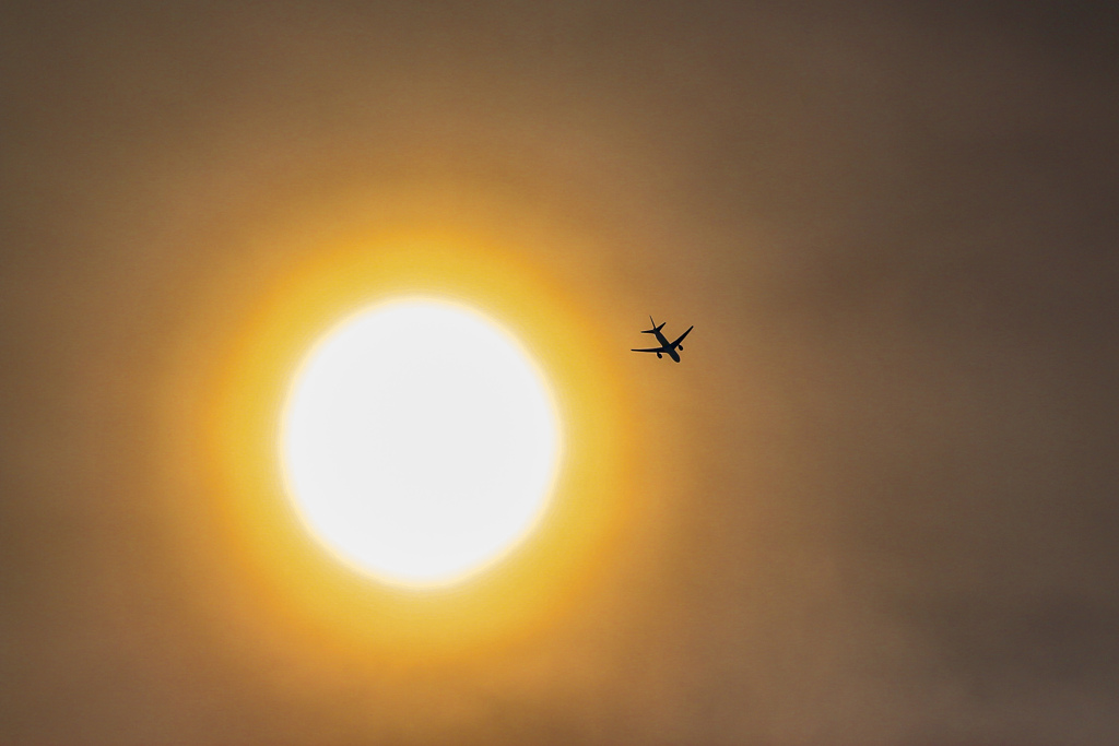 霞む太陽と飛行機