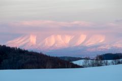 染まり始めた雲をかぶった山肌
