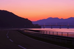 朝焼けに照らされる海と橋