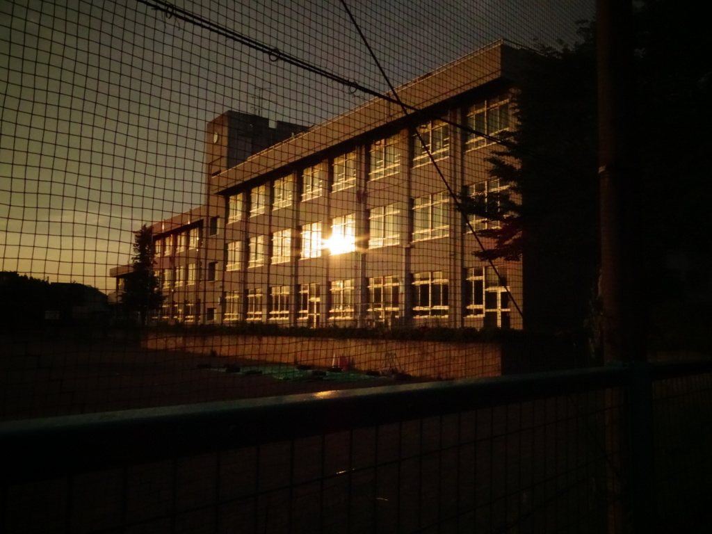 校舎の窓に映った夕陽