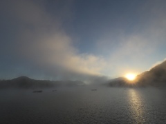 朝霧昇り立つ湖の日の出