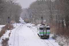 雪に埋まる元旦の待避線脇を行く、キハ40-1803