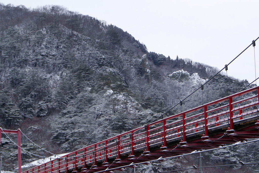 あゆのつり橋と雪化粧した屏風岩