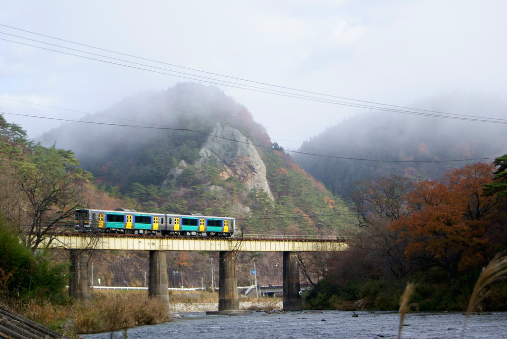 晩秋の久慈川を渡る水郡線と朝もやに包まれる大だるま岩