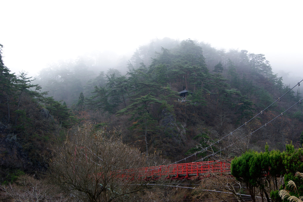 あゆのつり橋と朝霧に包まれる山の東屋