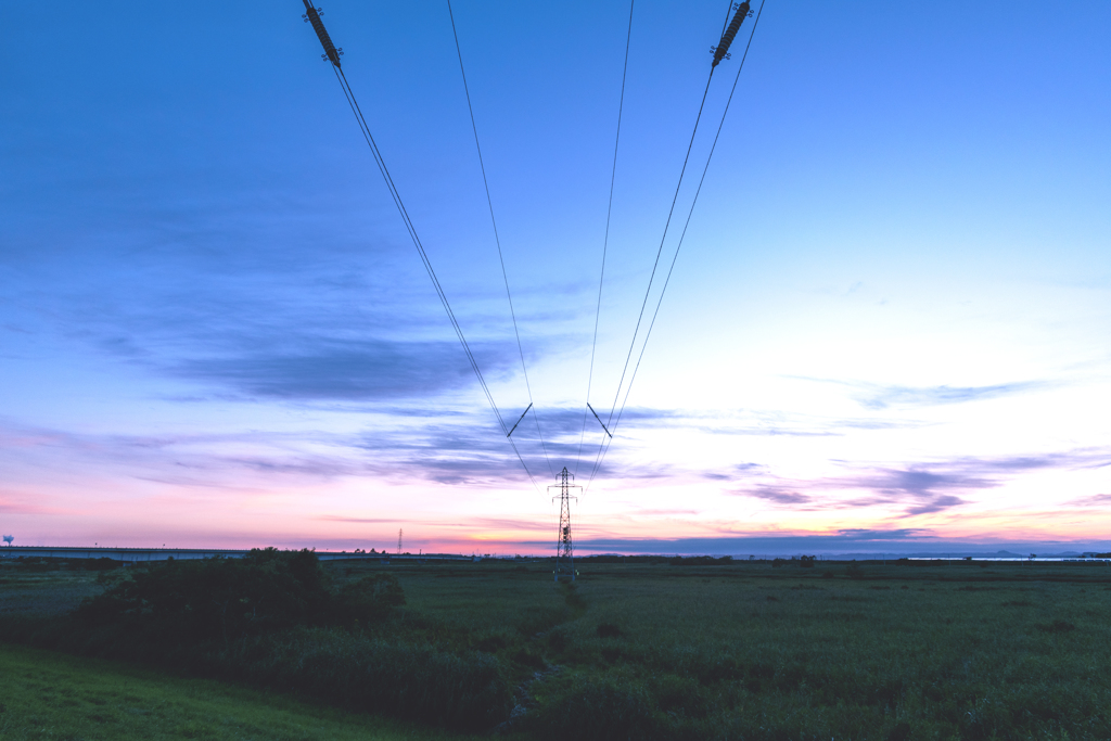 夕暮れの中の送電線