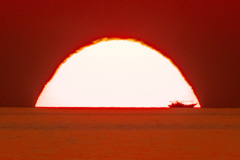 沈む夕陽と漁船