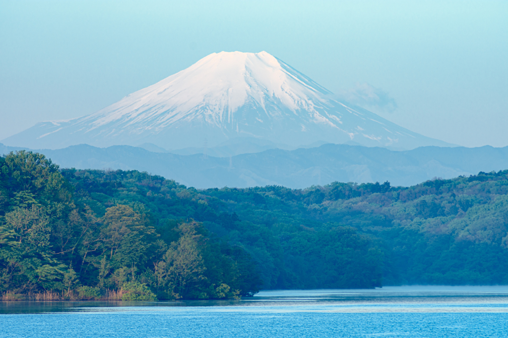朝靄の湖畔を照らす朝陽