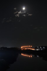 上弦の月と川面に映る橋の街灯