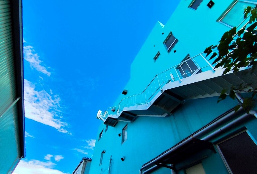 青い壁と白い階段の建物