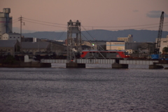 夕暮れの可動橋を行く機関車