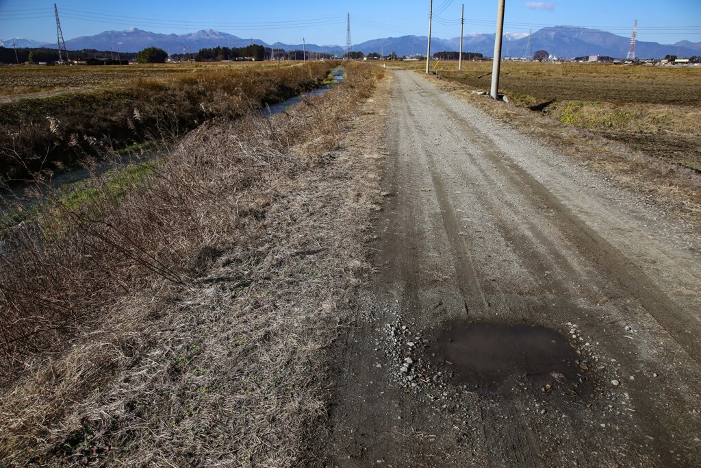 水たまりと砂利道