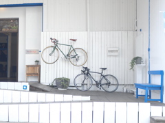 自転車と白い壁と青いベンチ。