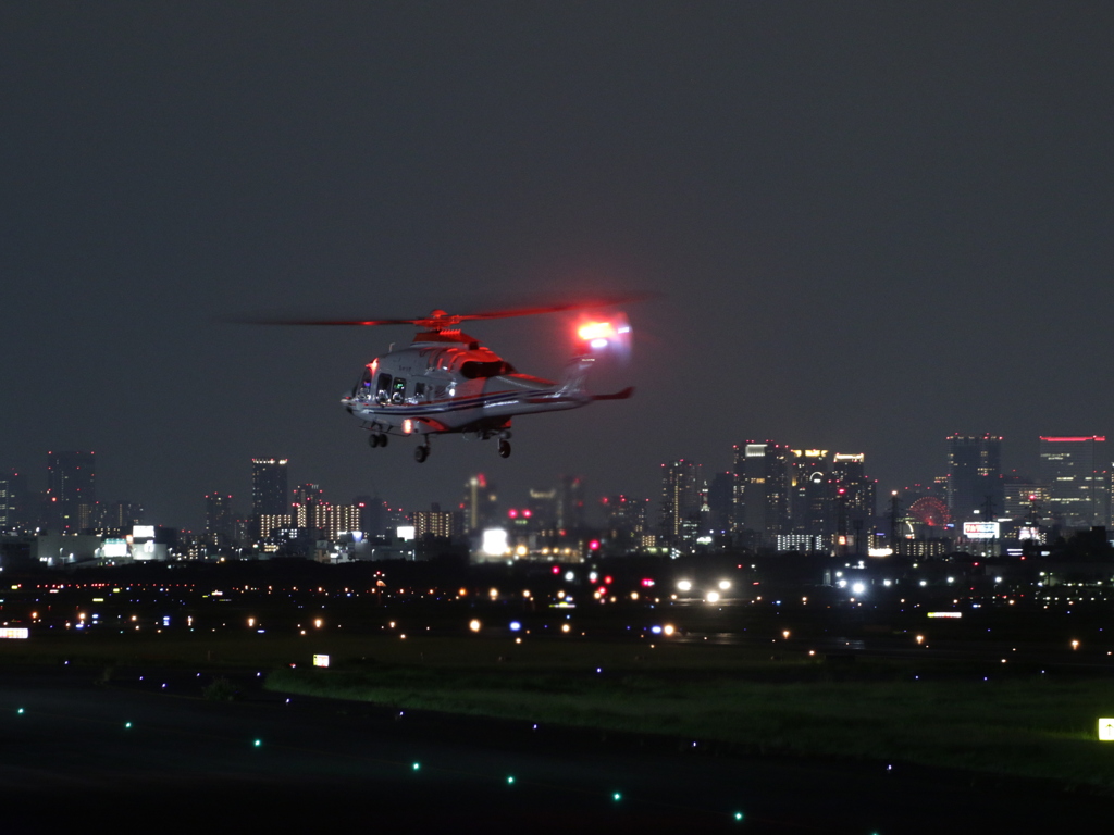 夜間離陸していくヘリコプター