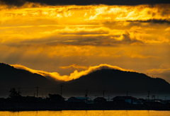 朝焼けと雲のうねる山