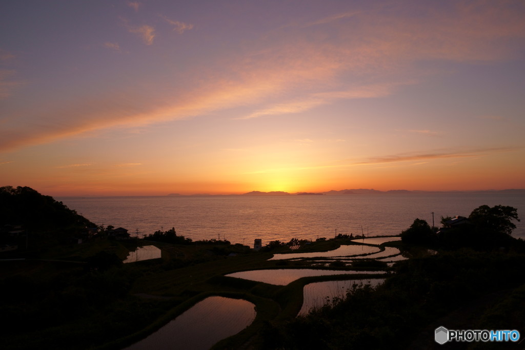 島影に沈みゆく夕日