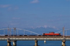 比良山に積もる雪と走る訓練列車