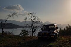 夕暮れの丘と車