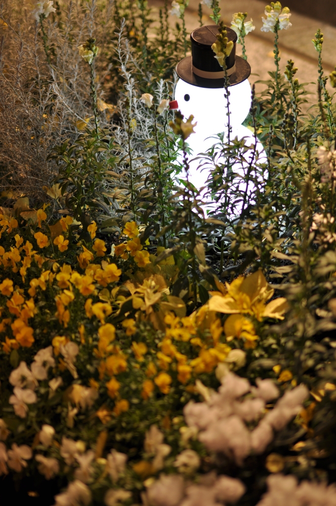 a snowman in a flower garden