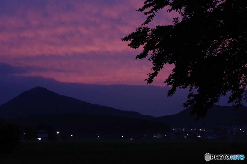 家の灯りと夕焼けと