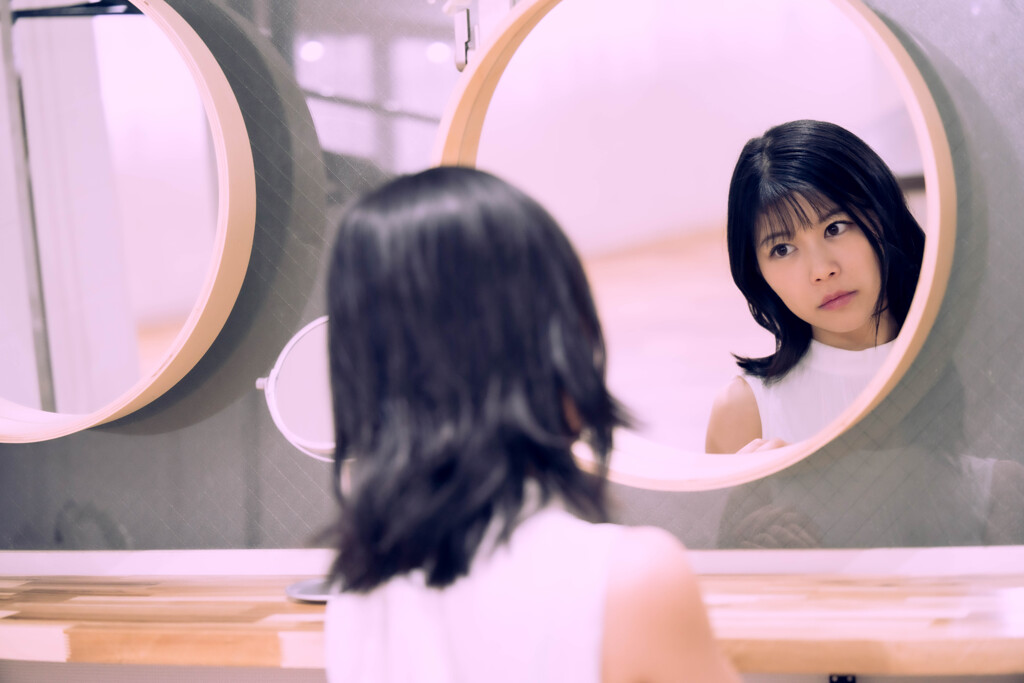 Her figure is reflected in the mirror.