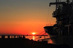 夕日と巡視船と釣り人