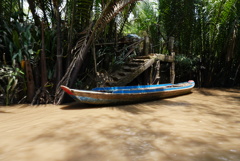 メコン川の支流にて木陰に浮かぶボート