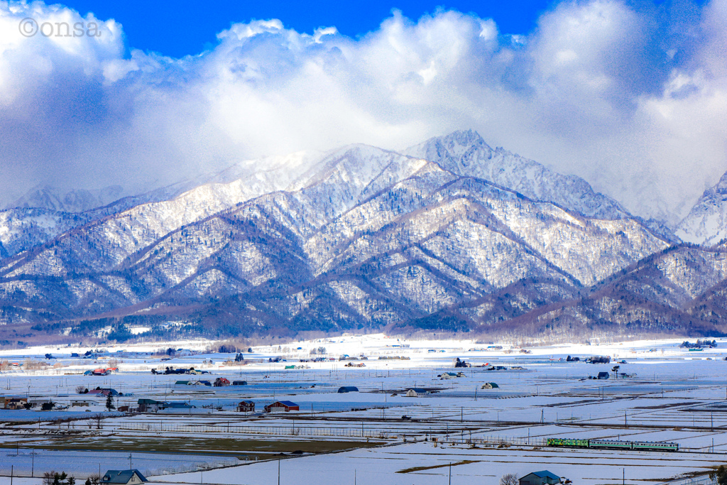 湧き立つ雲に聳える山、そしてもう走ることのない列車