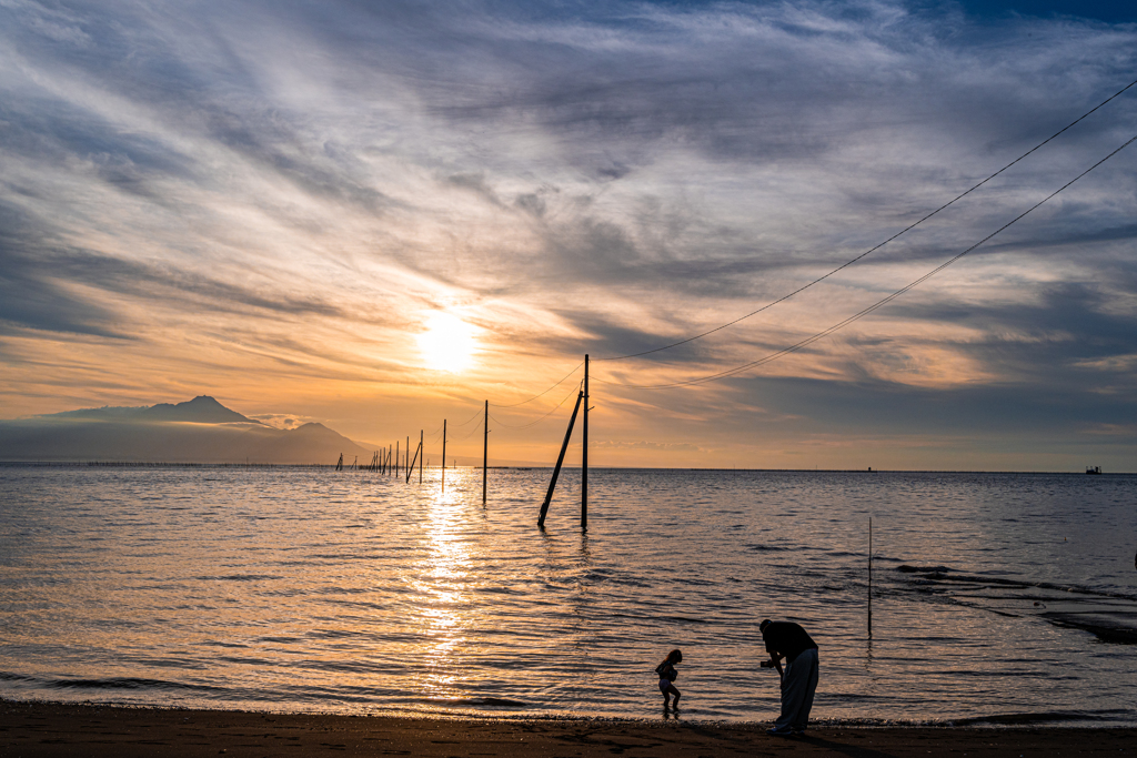 夕暮れの海辺で