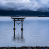 釣り人と鳥居と迫る雲