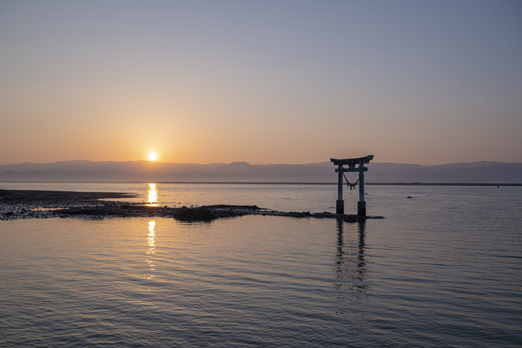 昇る朝日と海の鳥居