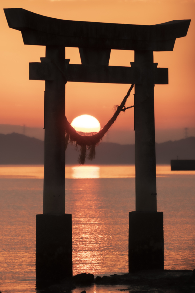 しめ縄に沈む夕陽