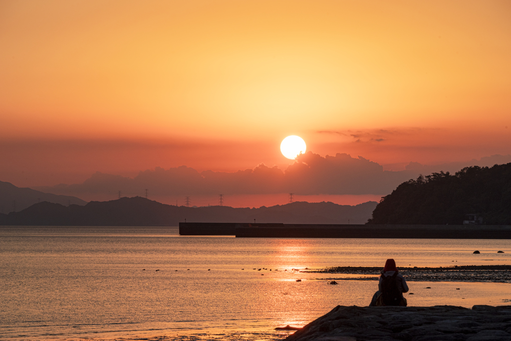 夕日を見つめる女性
