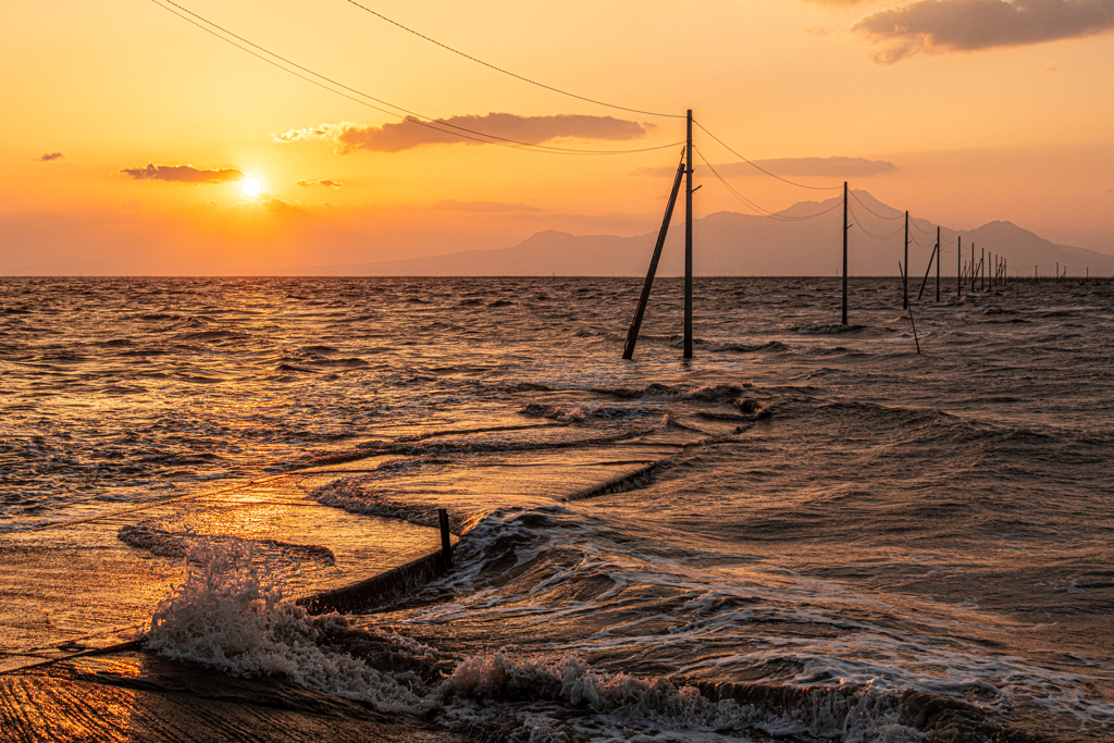 夕日と沈む海の道