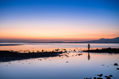 少年と夕日に染まる海と空