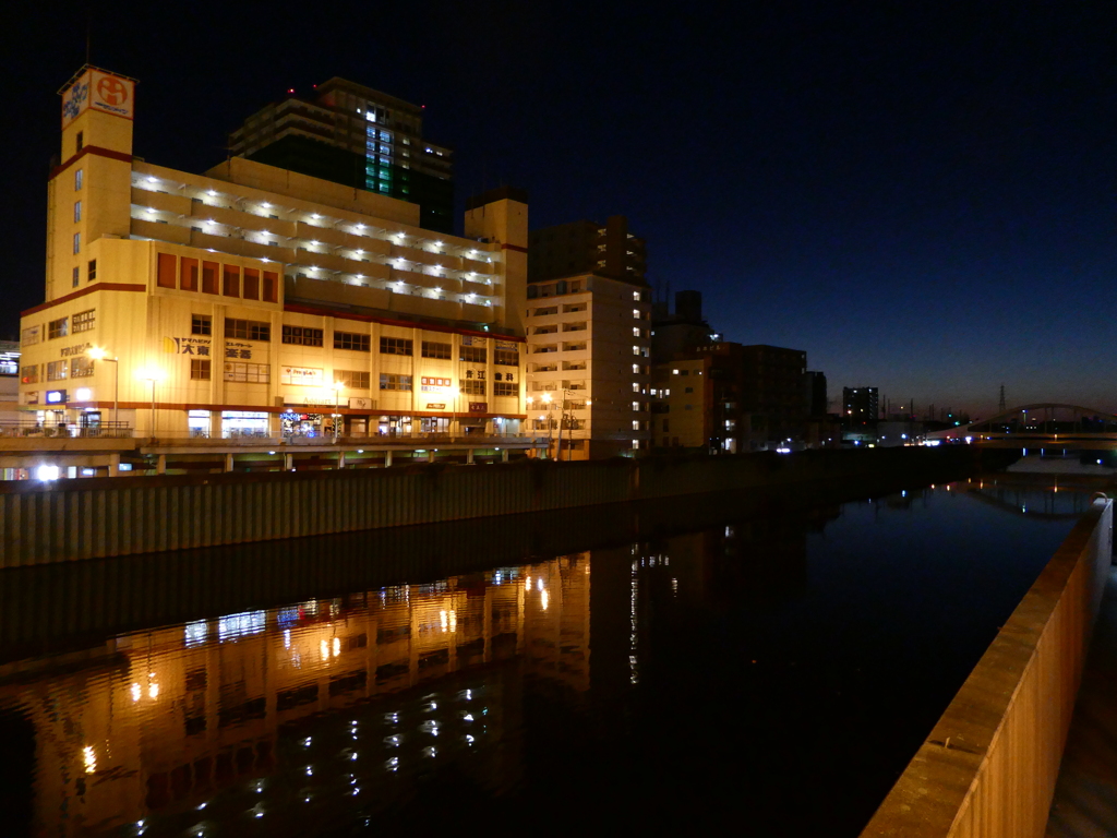 暮れの駅前のビルと河川