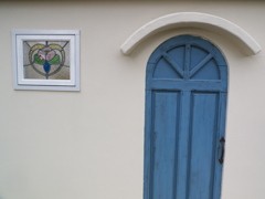 白い壁、青い扉、ステンドガラス窓