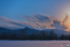 早春の雪原に夕陽