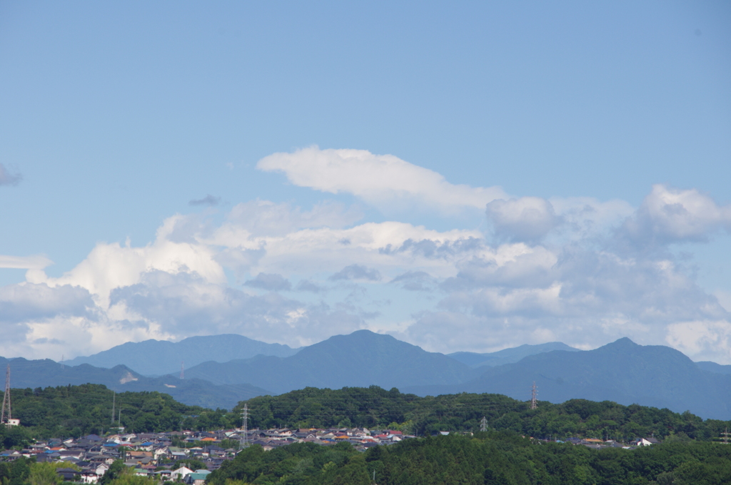 遠くの住宅街と山々を眺む