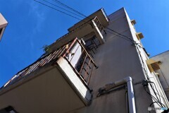 錆びた手すりと植物と換気扇