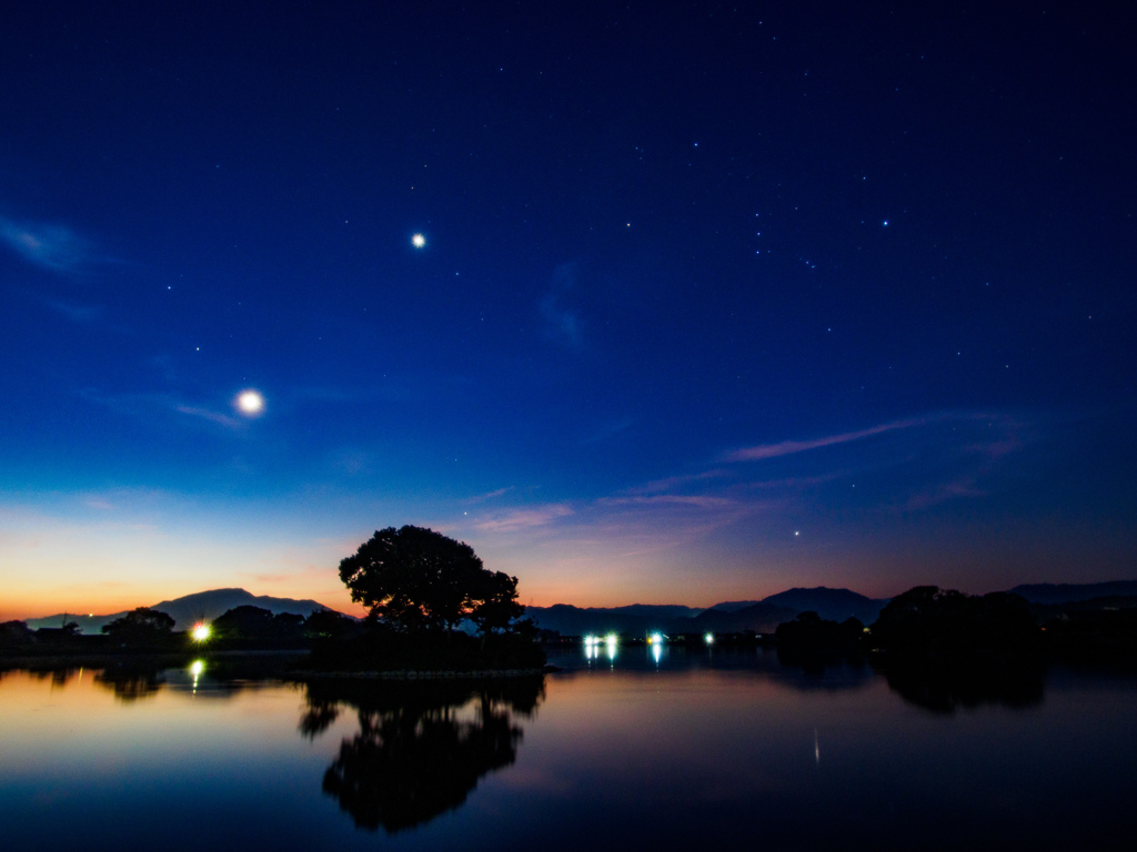 夜明け空に輝く月と金星とオリオン