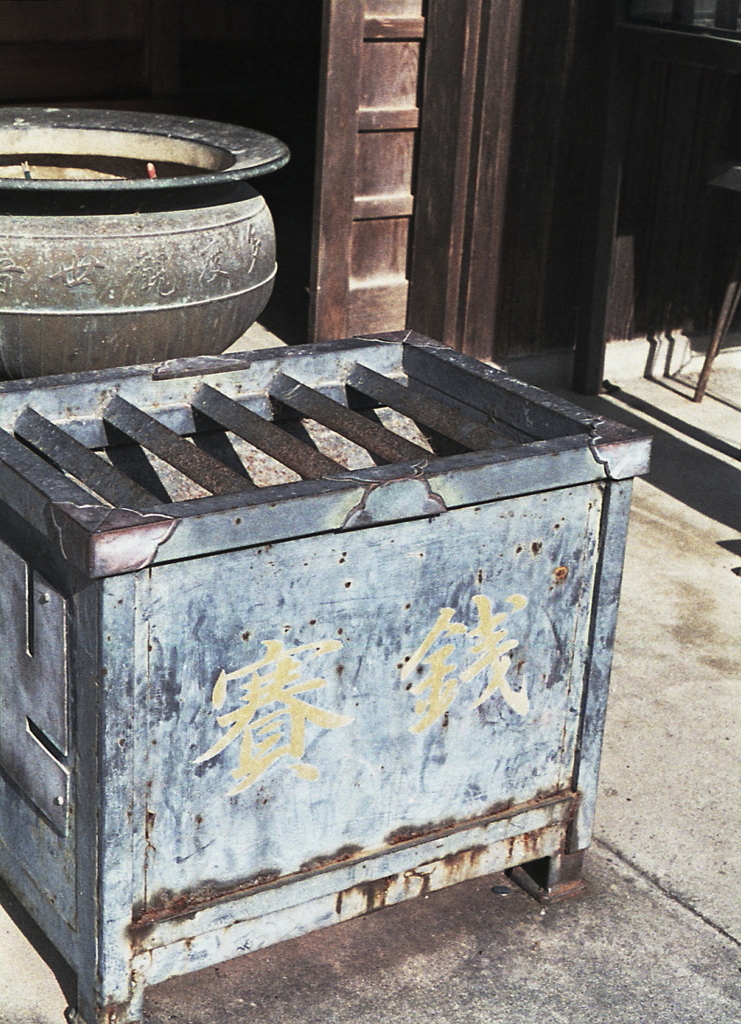 陽に照らされた賽銭箱