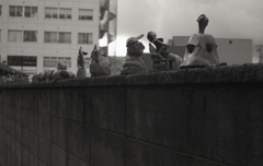 空き地のへいに並ぶ陶器人形